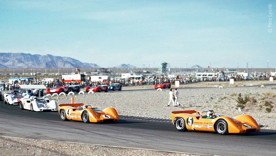 Дэнни Халм (#5) и Брюс МакЛарен (#4, оба на McLaren M6A Chevrolet) на первом круге гонки в Лас-Вегасе ’67. Позади Джим Холл (#66, Chaparral 2G Chevrolet) и Питер Ревсон (#52, Lola T70 Chevrolet).